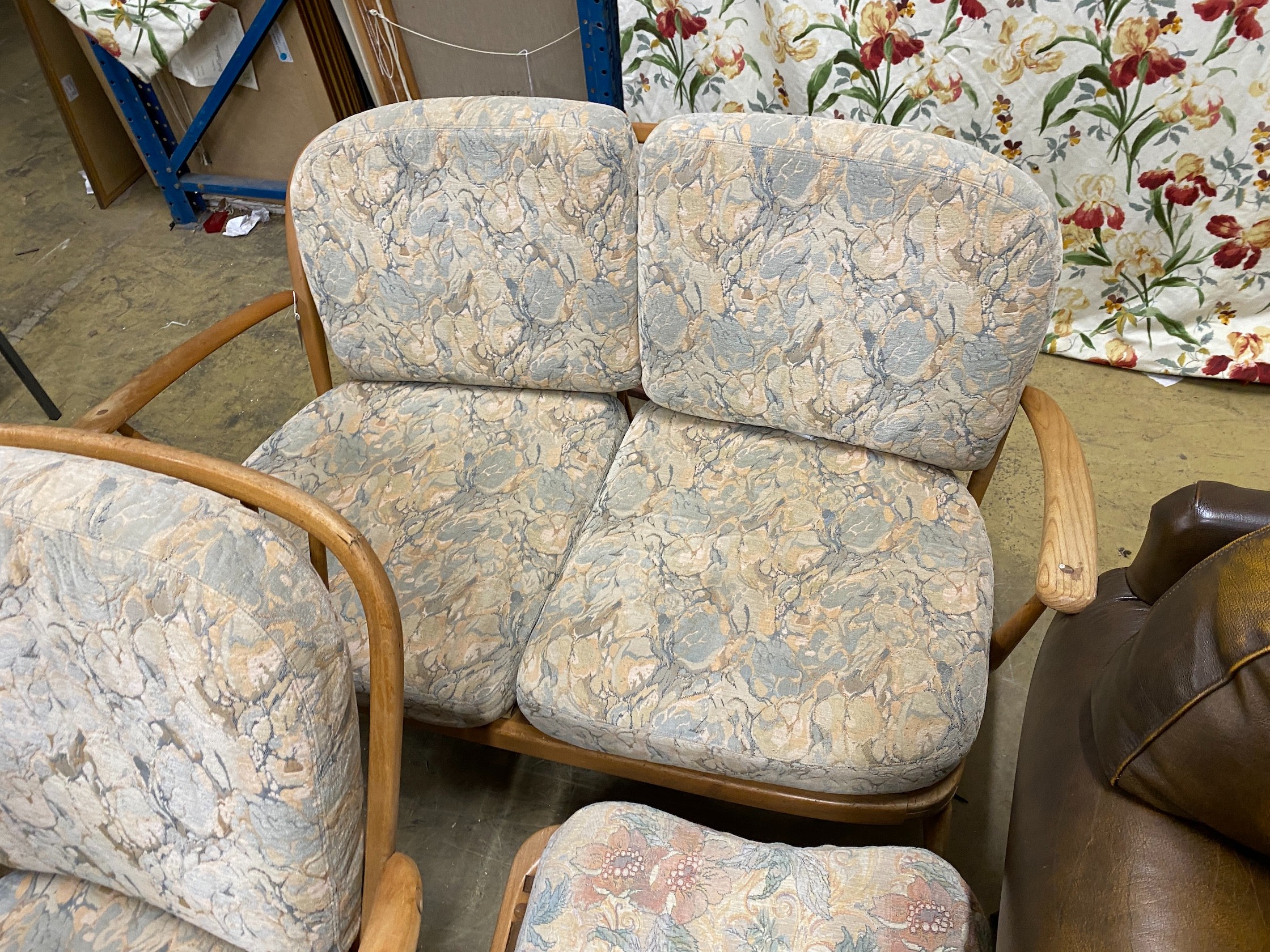 An Ercol elm three piece suite comprising settee, armchair and footstool
